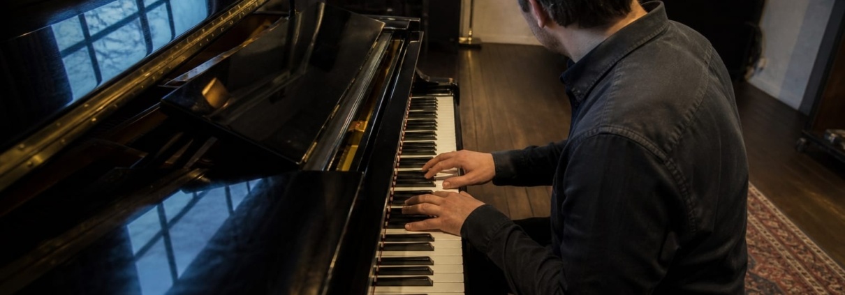 Chord inversions on the piano practised by a pianist at a grand piano