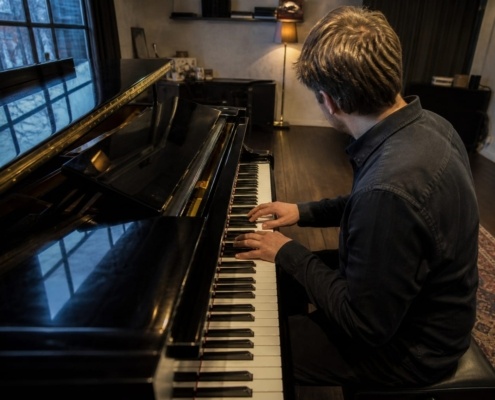 Chord inversions on the piano practised by a pianist at a grand piano