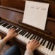Pianista leyendo cifrado de acordes en el piano, con C, G/B, Am7 y Fadd9 en una hoja